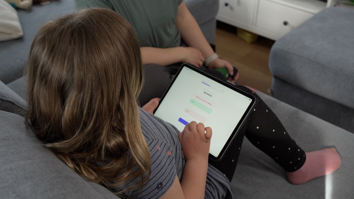 Kind entdeckt am Tablet eine App — gemeinsam mit einem Elternteil.